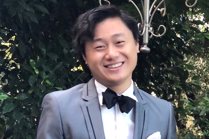 Photo of smiling Asian man wearing a tuxedo