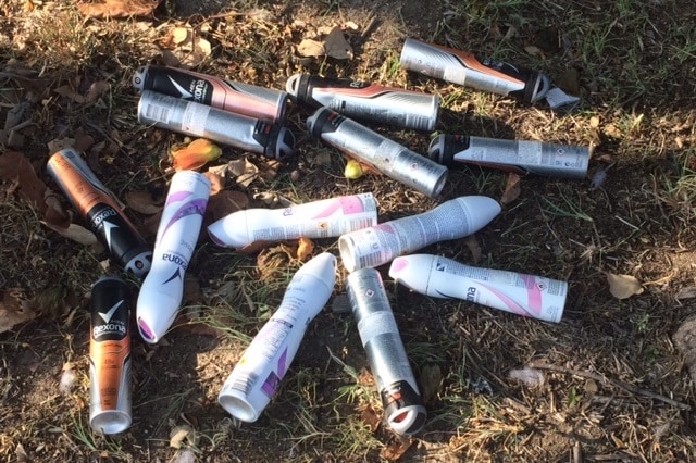 A collection of aerosol deodorant cans scattered on the ground