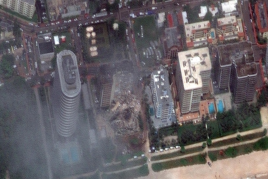 Vista dall'alto di un edificio crollato vicino alla spiaggia, vicino ai grattacieli