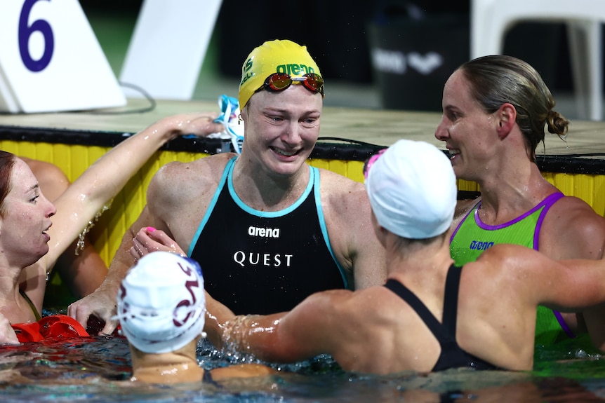 Cate Campbell is surrounded by other swimmers in the pool after her race
