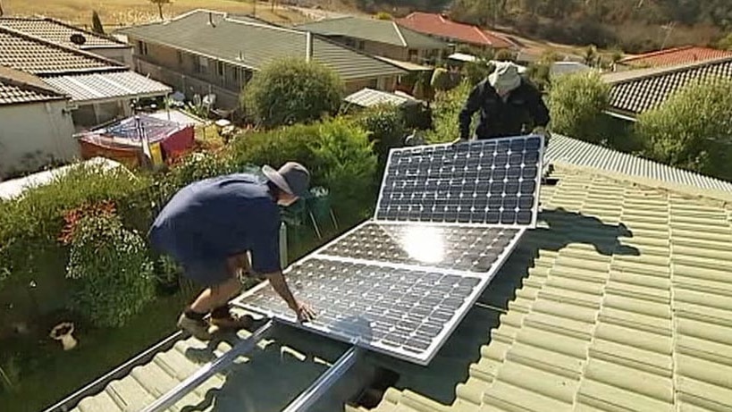 Men installing solar panels on a roof