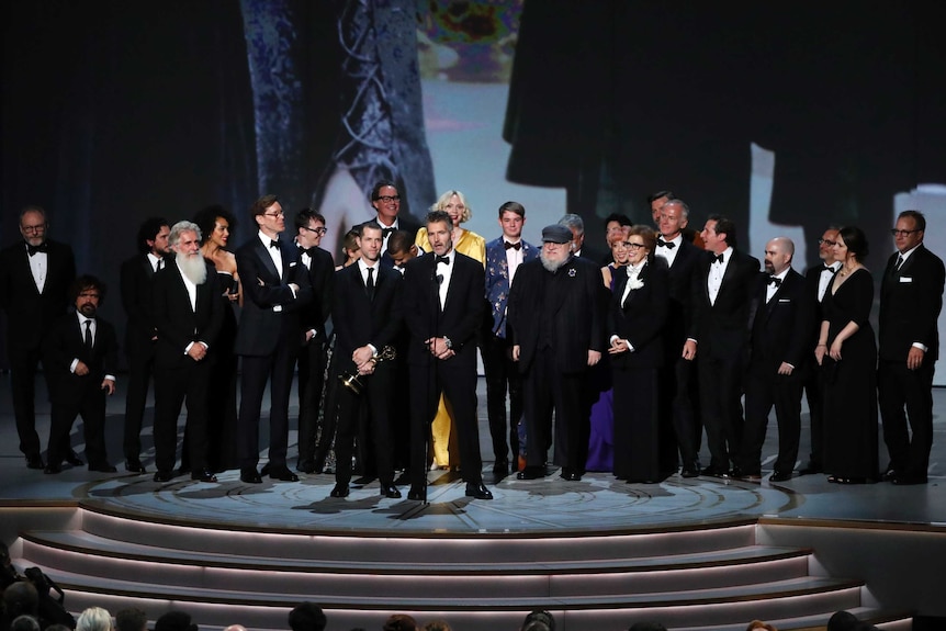 The cast of Game of Thrones accept their Emmy Award on stage