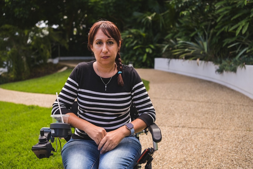 half close-up of a woman ina wheelchair staring sternly into the camera. 