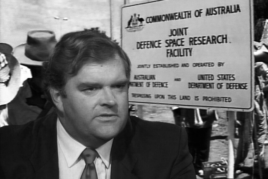 Black and white composite image of Kim Beazley and protesters outside of Pine Gap, NT.