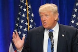 Donald Trump standing at a lectern delivering a speech.