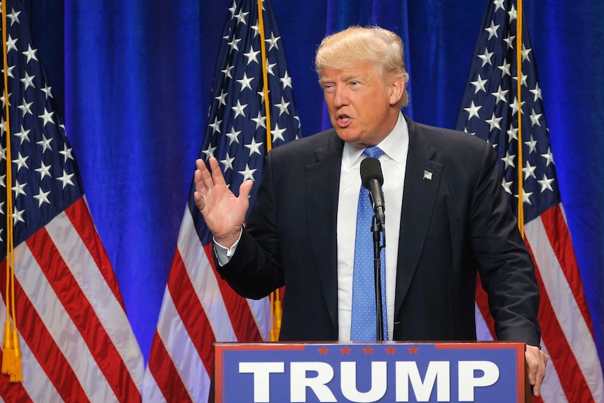 Donald Trump standing at a lectern delivering a speech.