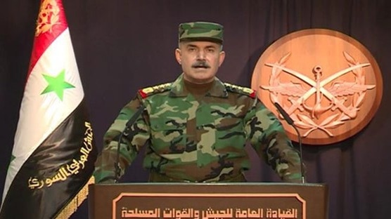 A Syrian army general stands at a podium on state television to declare victory in Aleppo.