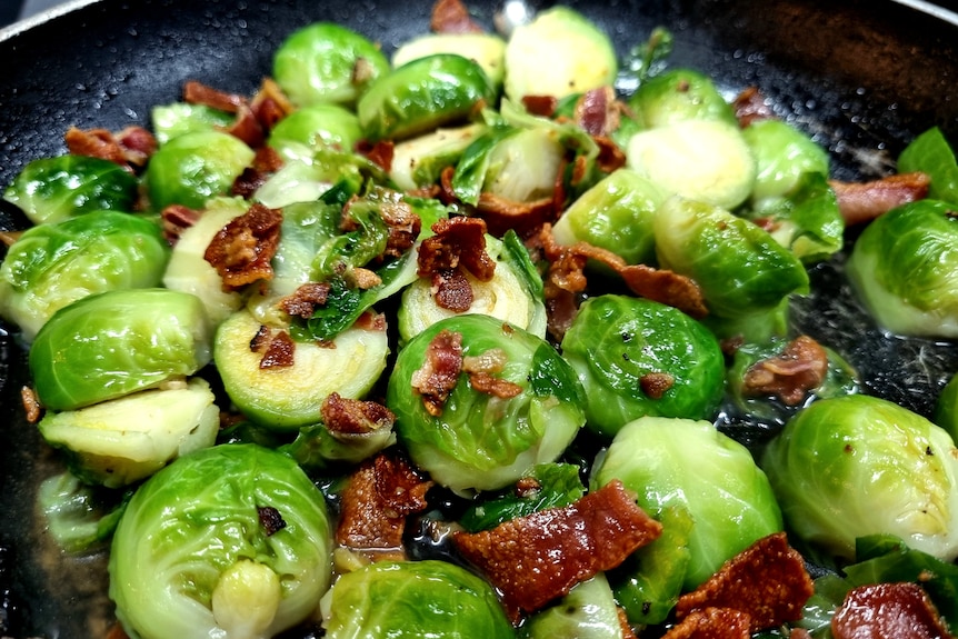 Pan of cooked brussels sprouts with truffled honey and pancetta.