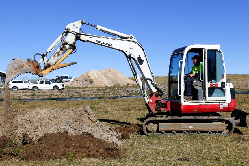 An excavator digs up dirt.