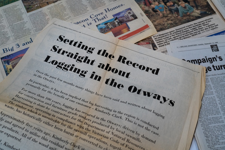 A pile of newspapers on a table. The top one says "setting the record straight about logging in the Otways".
