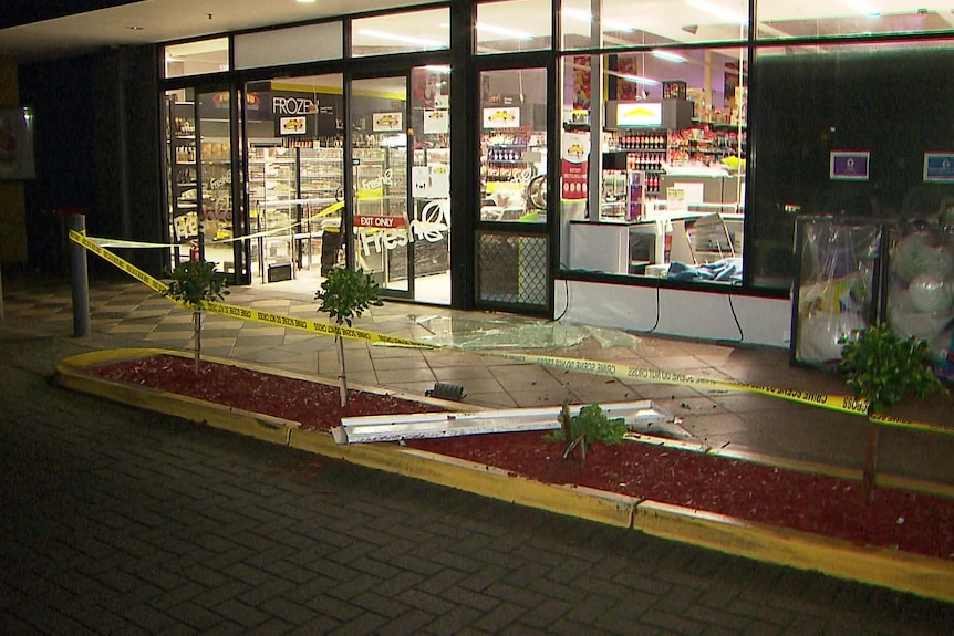 Glass doors of a supermarket, with yellow tape across it