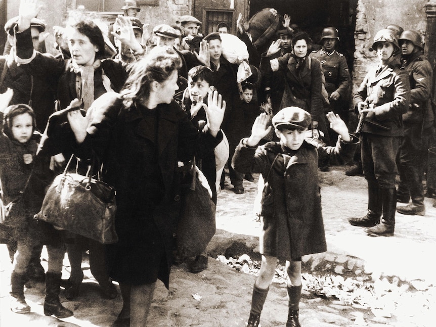 German storm troopers force Warsaw ghetto dwellers to keep moving during the Jewish Ghetto uprising.