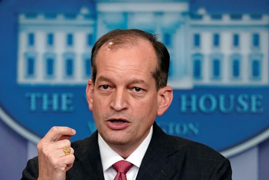 Alex Acosta talking to the media in front of a White House logo.