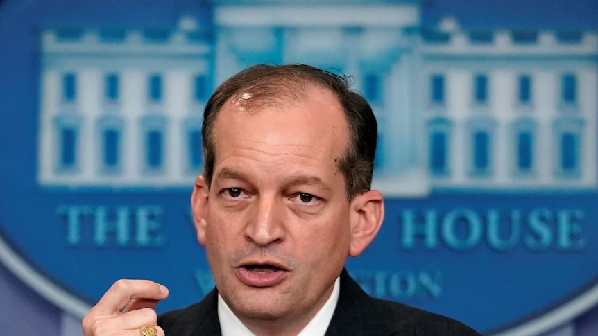 Alex Acosta talking to the media in front of a White House logo.