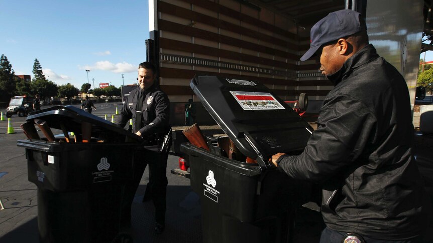 LA police officers load bought-back guns into bins