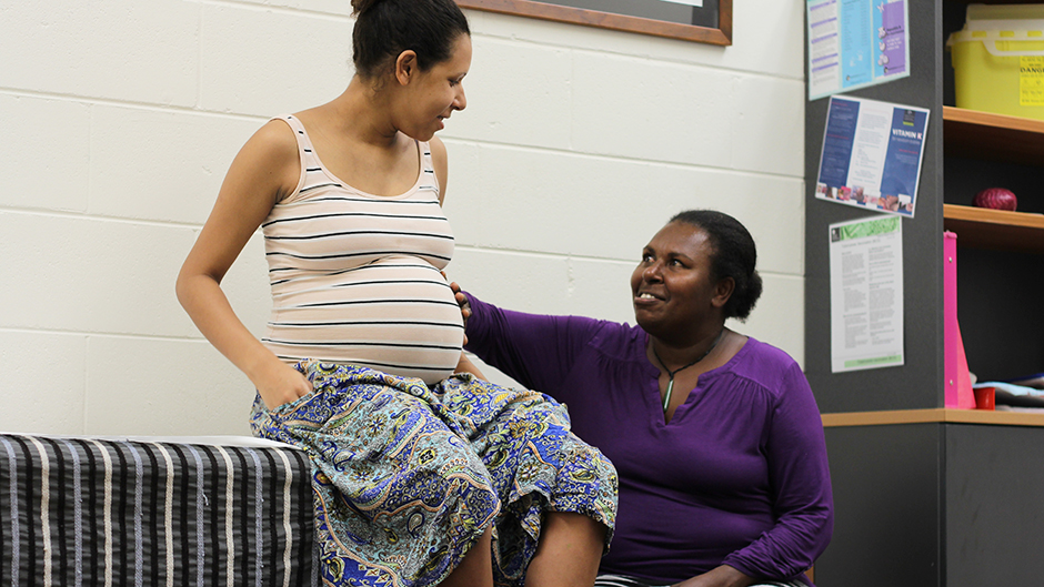 A pregnant young woman and a smiling older woman