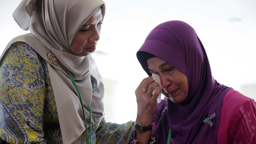 A family member cries after an MH370 closed door meeting in Putrajaya, Malaysia.