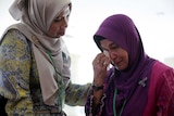 A family member cries after an MH370 closed door meeting in Putrajaya, Malaysia.