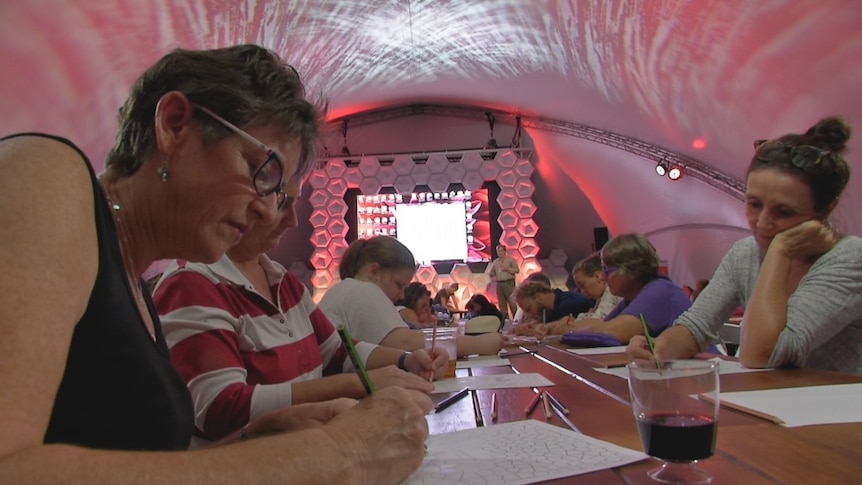 People colour in during a presentation at the science fair