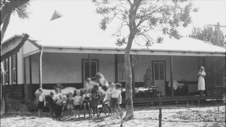 A black-and-white photo shows a group of children.