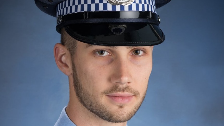 A young policeman in uniform in an official portrait