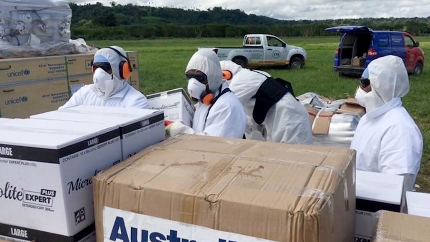 Royal Australian Air Force personnel unload pallets of humanitarian aid in Port Villa, Vanuatu.