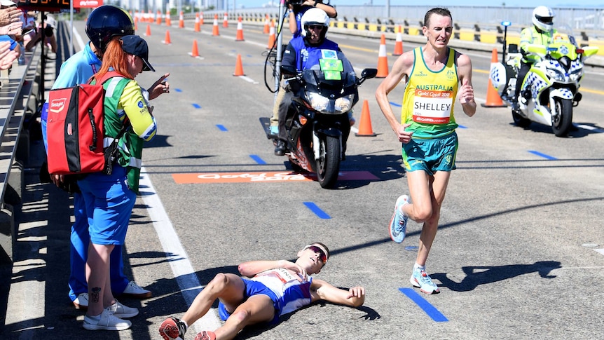 Michael Shelley of Australia (right) passes Callum Hawkins of Scotland as he collapses.