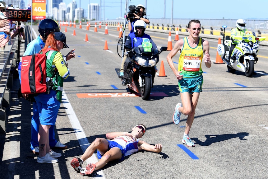 Michael Shelley of Australia (right) passes Callum Hawkins of Scotland as he collapses.