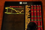 An investor looks at a graph showing the All Ordinaries Index at the Australian Stock Exchange in Sydney