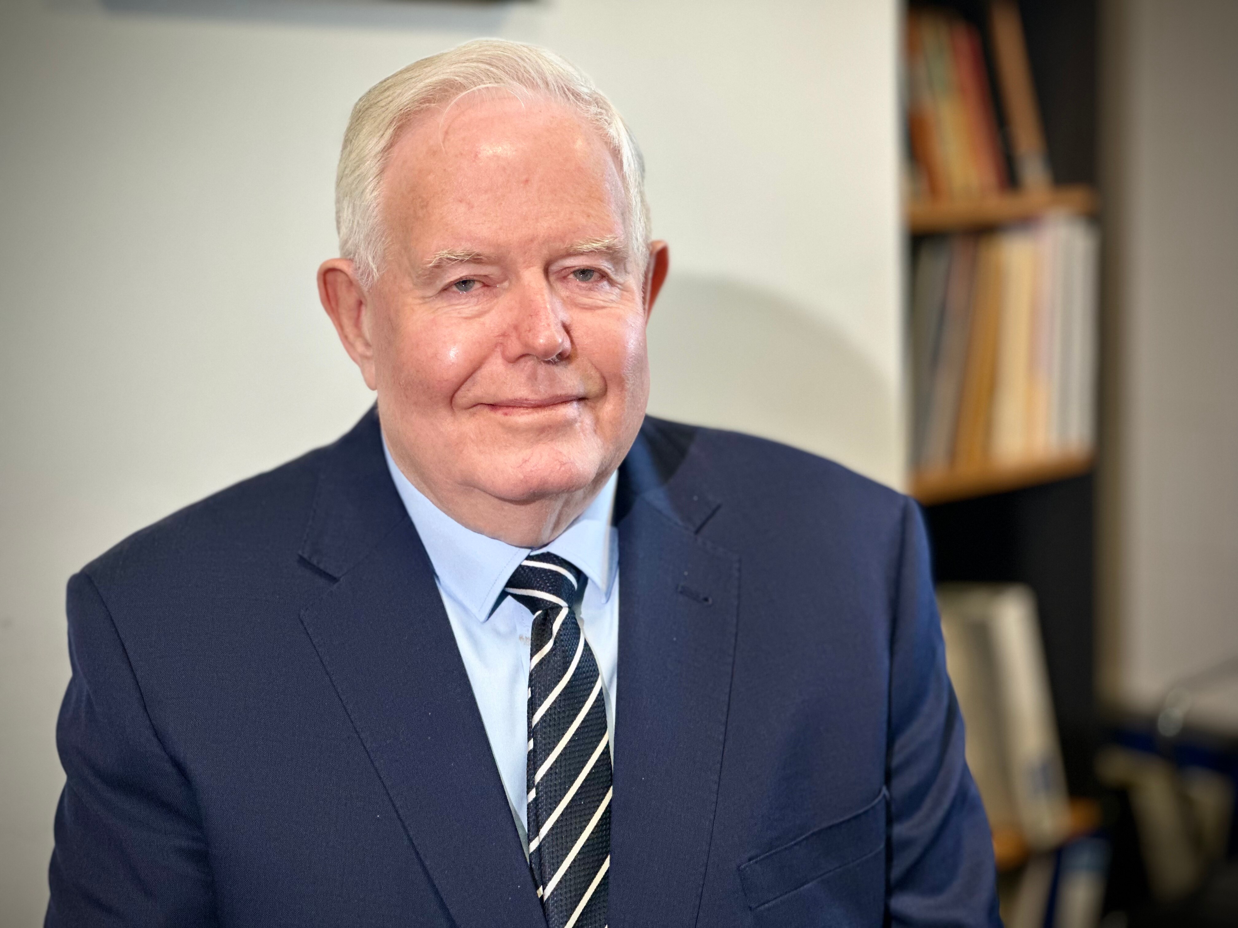 Professor Glen Maberly from sydney university looks at the camera smiling while sitting inside and office