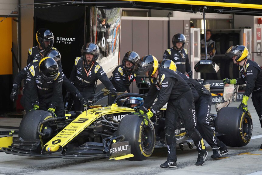 Daniel Ricciardo's black and yellow Renault car is wheeled into the pits in Sochi