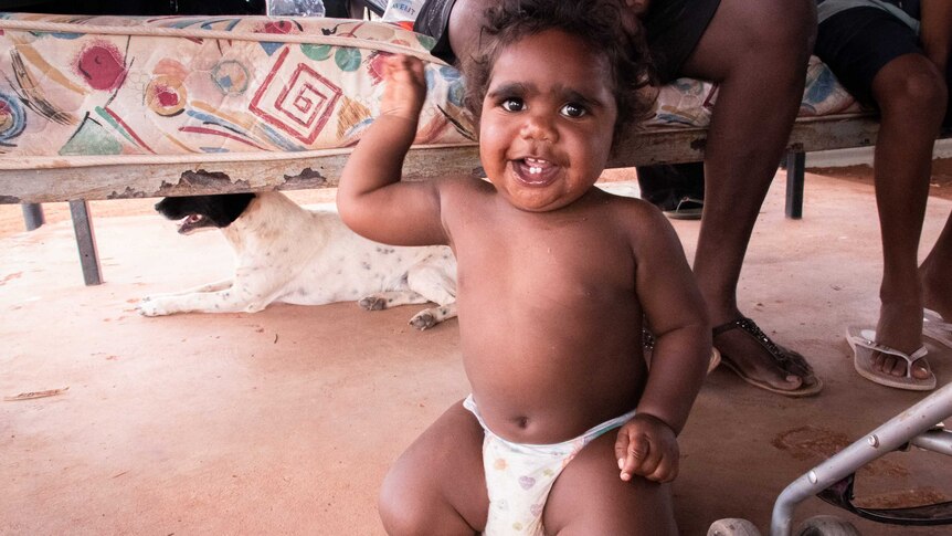 A small Indigenous child smiles for the camera.