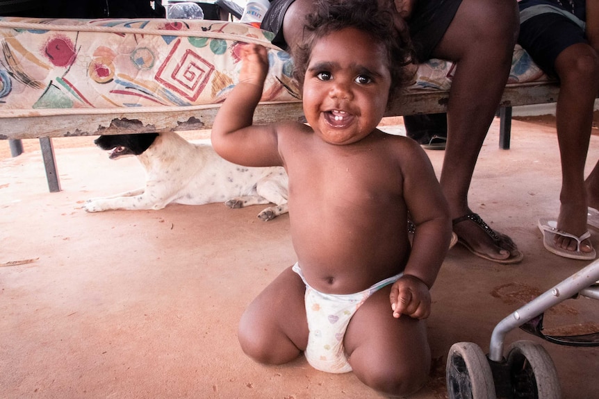 A small Indigenous child smiles for the camera.