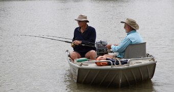 Two older men in a metal dingy fishing