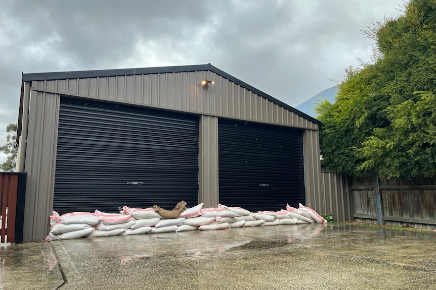Large shed with two roller doors with sandbags in front 
