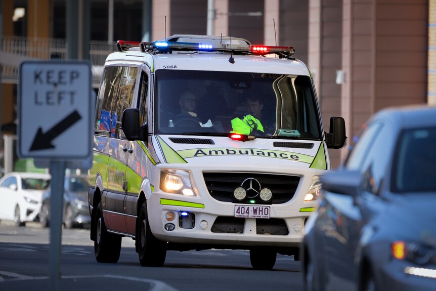 A Queensland ambulance on a busy city street