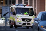 A Queensland ambulance on a busy city street