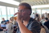 a young man drinking a beer at the pub