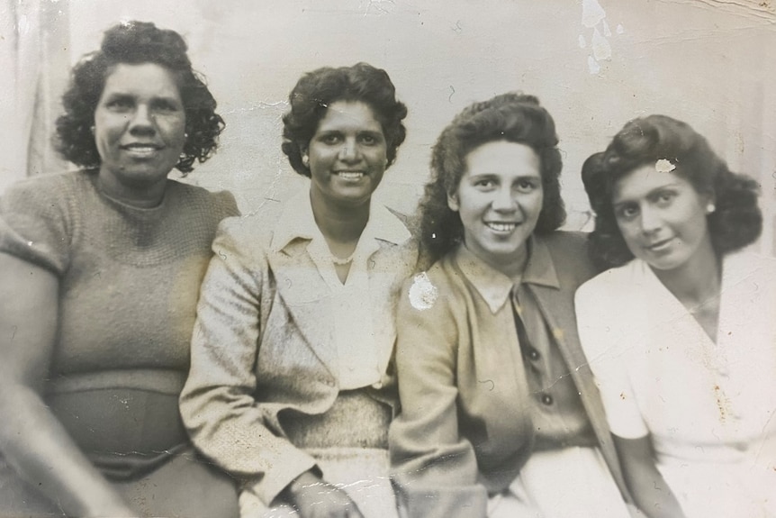 a group of four young women smiling