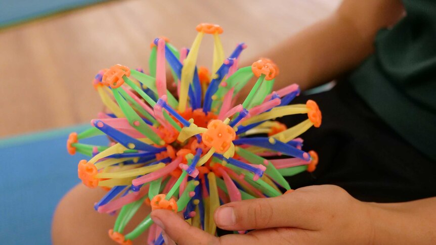 Close up of a  plastic expandable breathing ball in a child's lap