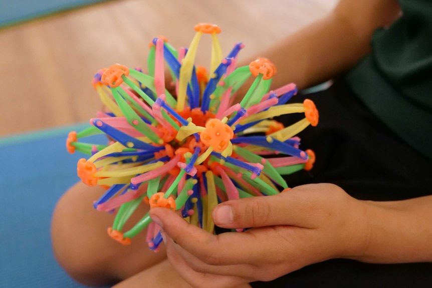 Close up of a  plastic expandable breathing ball in a child's lap