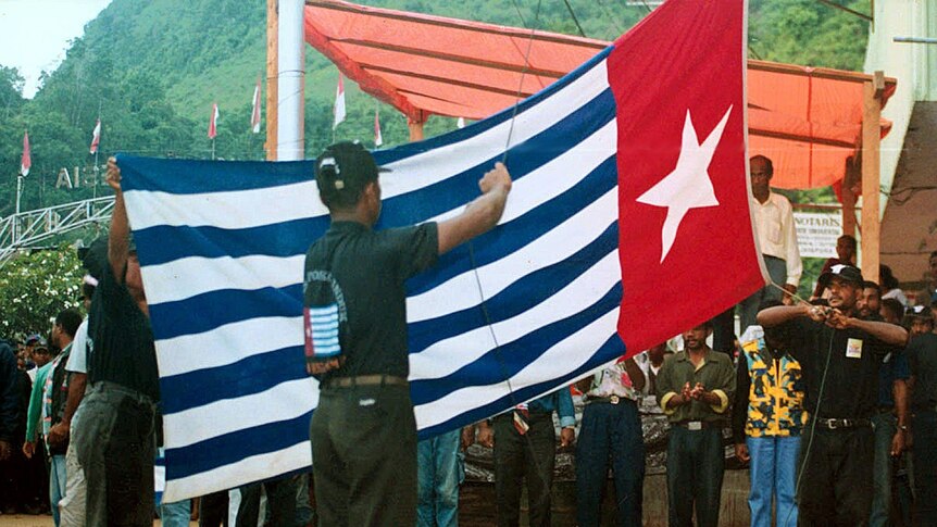 Independence supporters hoist the separatist Morning Star flag at Jayapura, Papua province, Indonesia