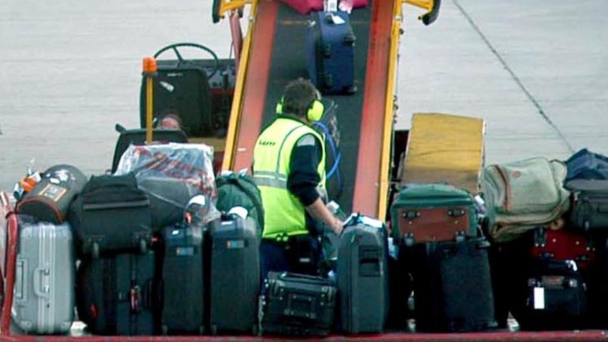 Qantas baggage handlers load bags onto a domestic Qantas jet
