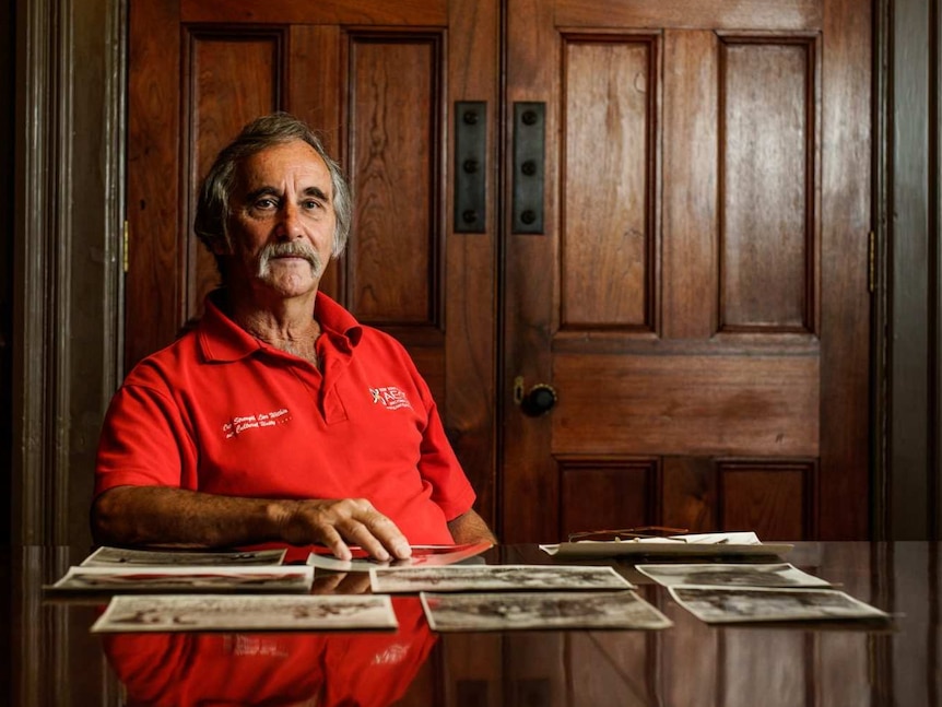 Man sitting at desk with photographs