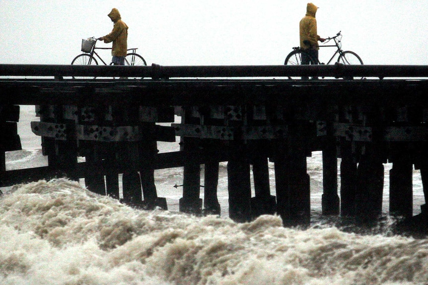 Cyclists watch the floods.
