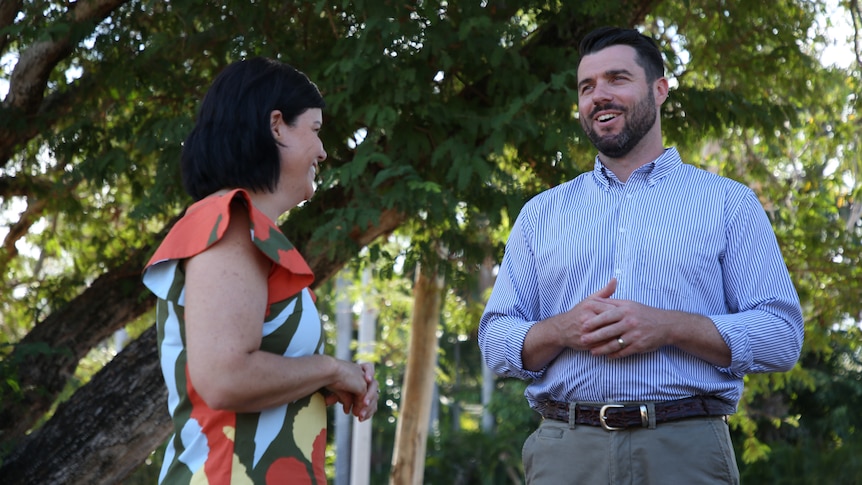 NT Chief Minister Natasha Fyles and Fannie Bay Labor candidate Brent Potter talking and laughing under a tree on a sunny day.