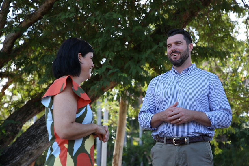 NT Chief Minister Natasha Fyles and Fannie Bay Labor candidate Brent Potter talking and laughing under a tree on a sunny day.