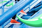 Close-up of red shoes running up a set of blue stairs to depict the benefits of short bursts of exercise vs longer sessions.