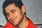 Close up of man in red t-shirt smiling at camera