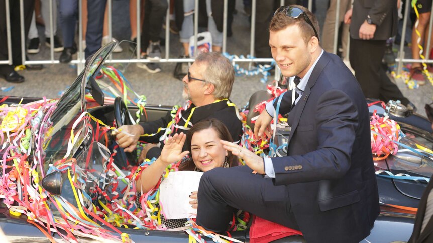 Jeff Horn and his wife Jo wave from the car at Brisbane ticker tape parade